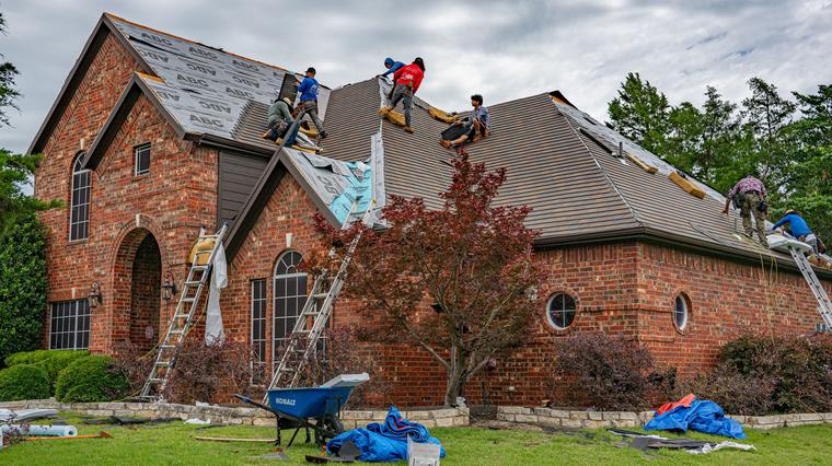 Roofing crew replacing the roof of a brick home in Allen, Texas